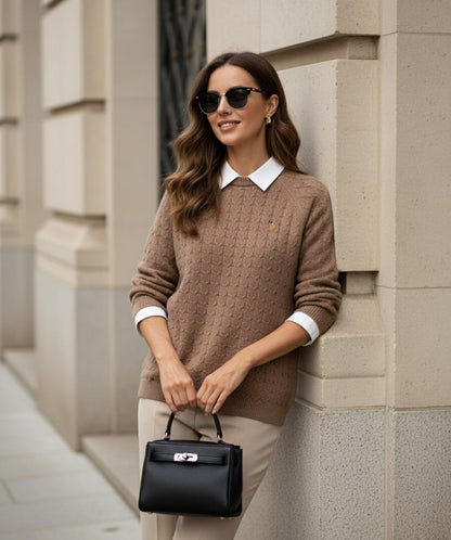 Woman wearing gold cable knit sweater over a white collared shirt