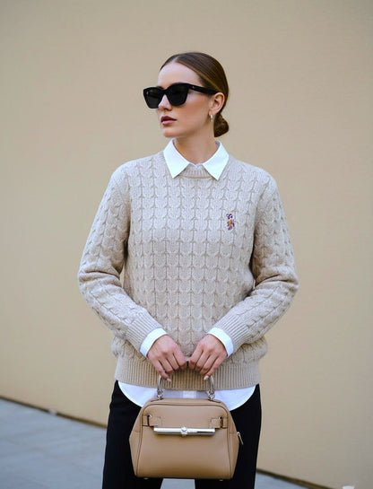 Woman wearing beige cable knit crewneck sweater