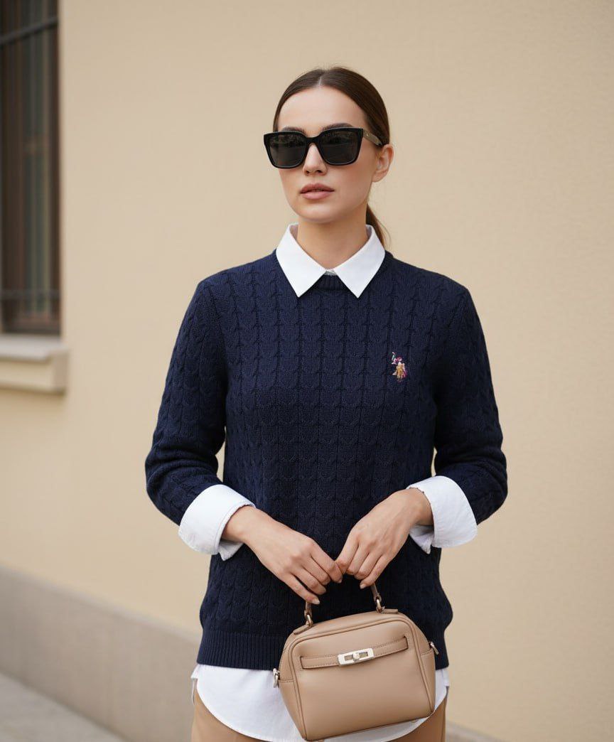 Woman wearing navy cable knit crewneck sweater