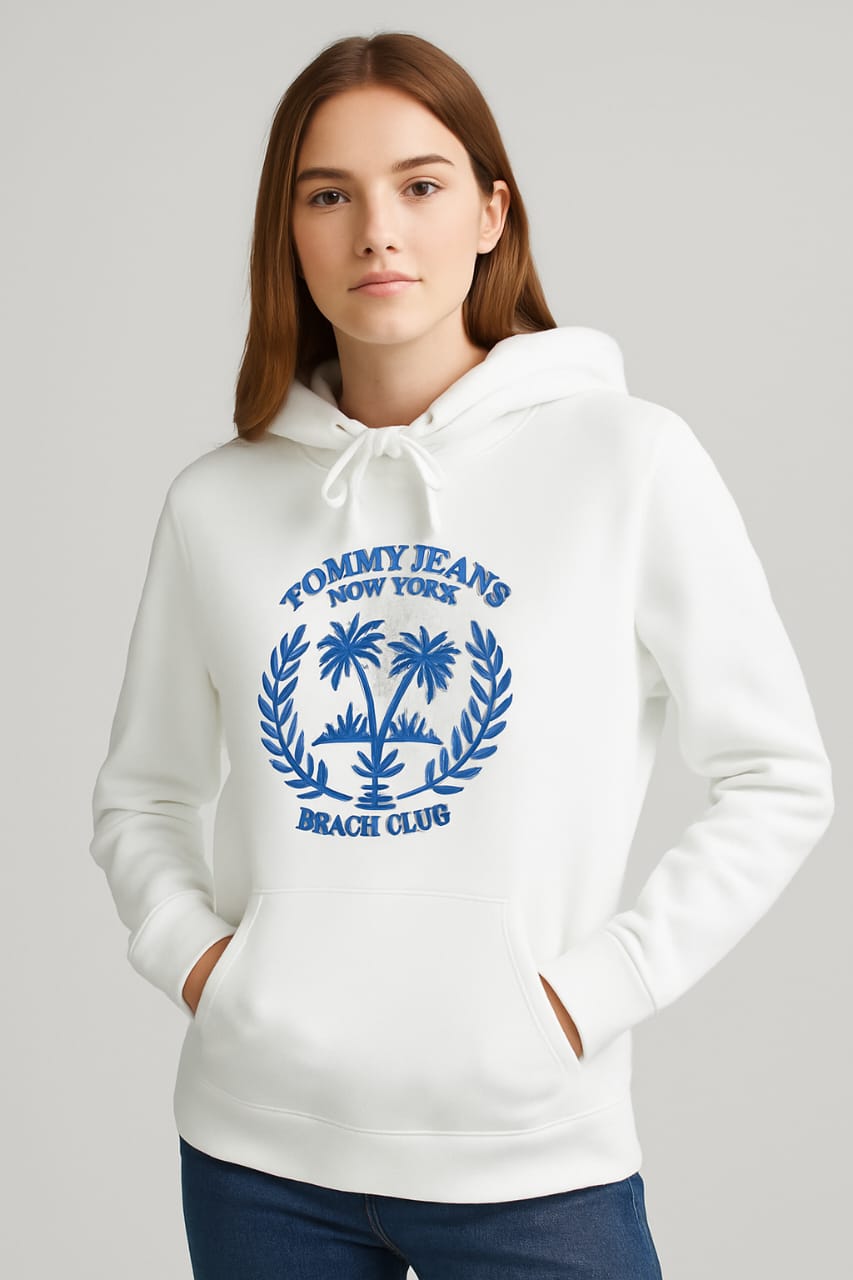 Woman wearing white embroidered Beach Club hoodie with blue palm tree crest